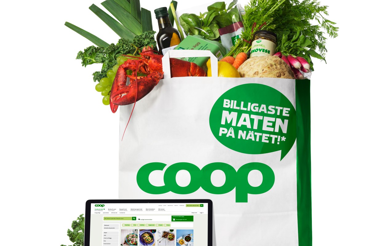 Bild på en full papperskasse med grönsaker, framför en laptop med Coops webbsida visad.