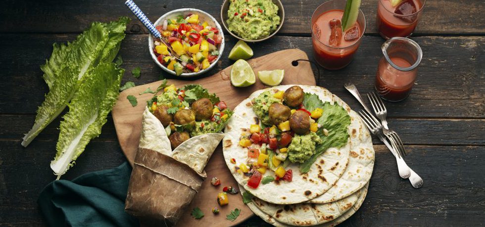 Wrapmåltid uppdukad med olika skålar med röror och Grönsaksbullar på