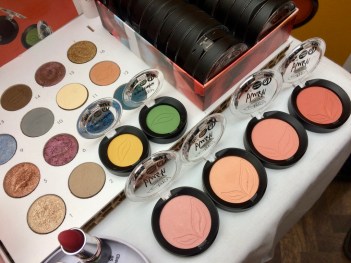 Ögonskuggor i starka färger uppradade på bord, sedda uppifrån