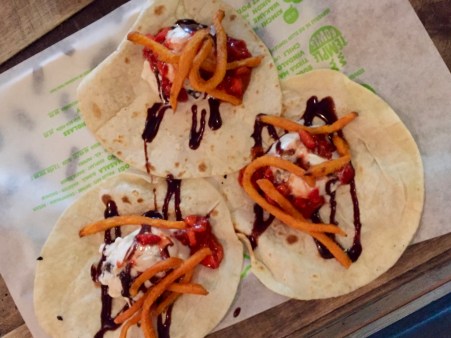 Runda, tunna bröd med glasskula på, toppad med mörk sås och sötpotatispommes