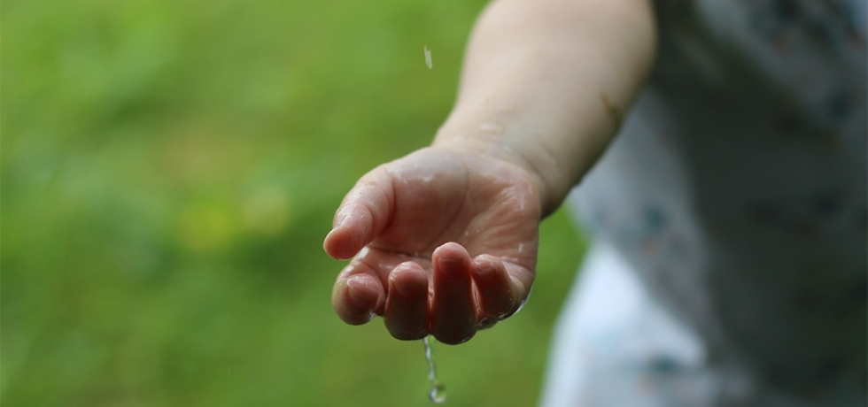 En hand hålls fram för att fånga vattendroppar
