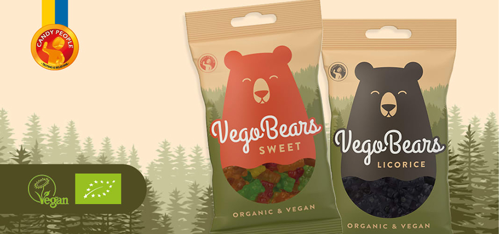 Två godispåsar med illustrerade björnar på, en roströd och en svart. Tillvänster veganmärkning