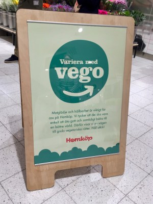 En "gatupratare" i trä med sylten "Variera med vego" på