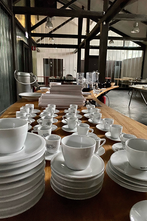 Kaffekoppar på fat uppradade på ett bord