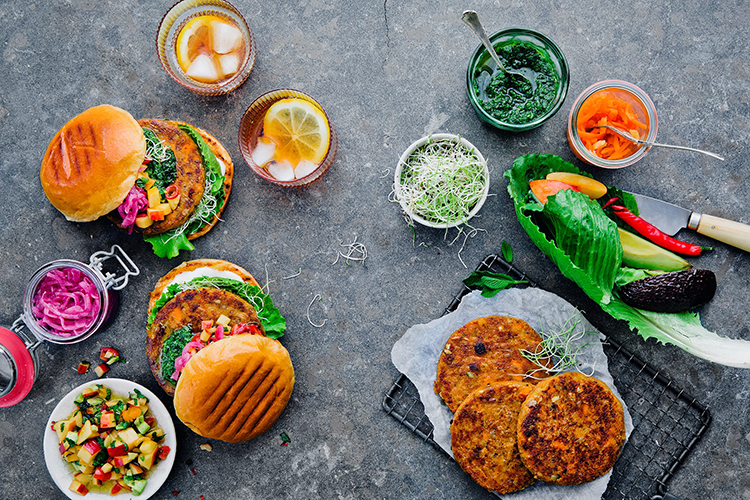 Biffar och skålar med såser och grönsaker sedda uppifrån
