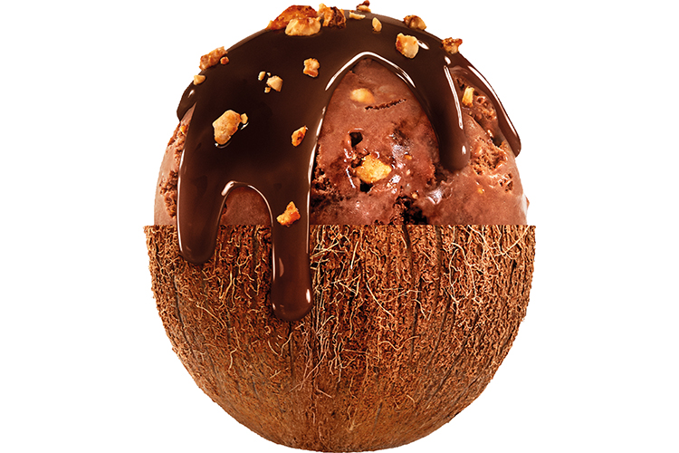 Halverad kokosnöt fylld med glass och toppad med chokladsås och nötter