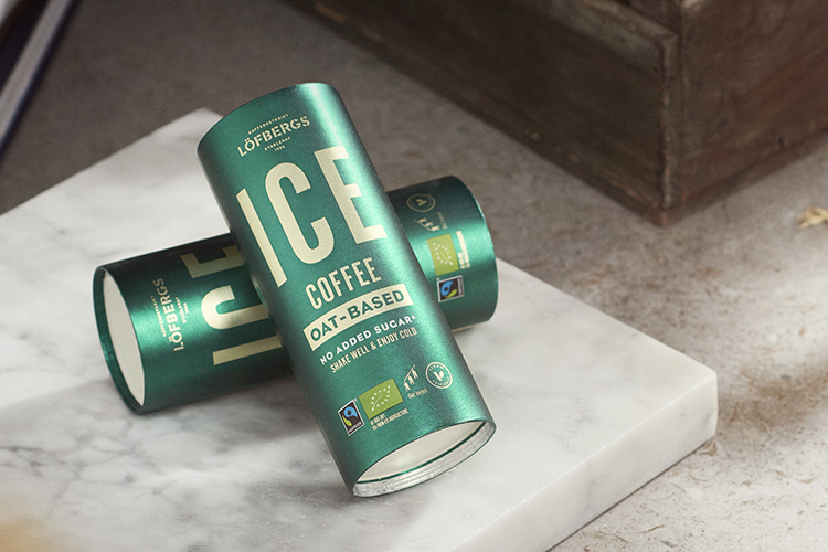 Två gröna, cylinderformade förpackningar med texten ICE coffee i guld