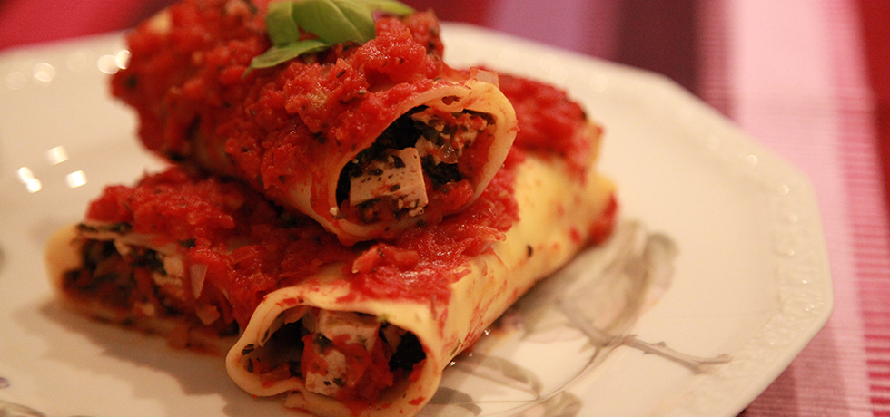 Tre cannellonirullar på en tallrik med tomatsås ovanpå