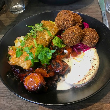 Tallrik med falafel, börek, grönsaker och hommus