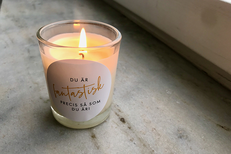 Ett tänt ljus med texten Du är fantastisk på