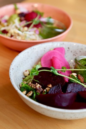 Sallad med rödbetor, nötter och grönt i skål på bord