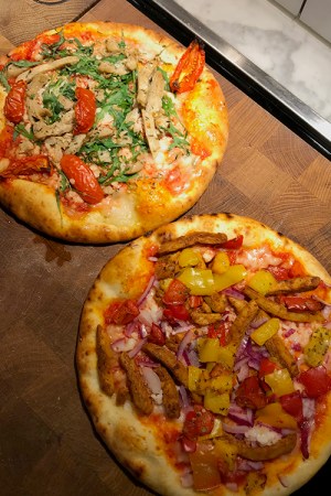 Två pizzor på en stor skärbräda