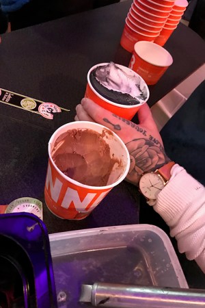 Två glassbägare, en tatuerad hand håller i den ena