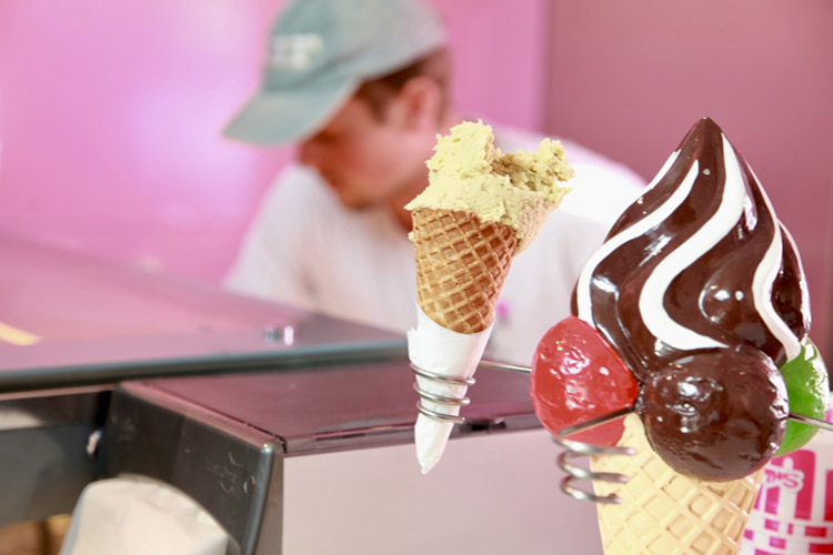 Glasstrut i en struthålare, en person med keps i bakgrunden