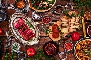 Korvar, frukt och röror på ett träbord med granris och äpplen som dekoration