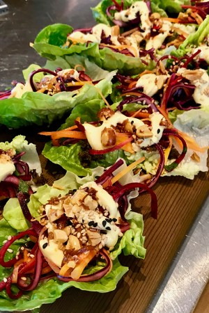 Salladsblad formade som båtar fyllda med grönsaker