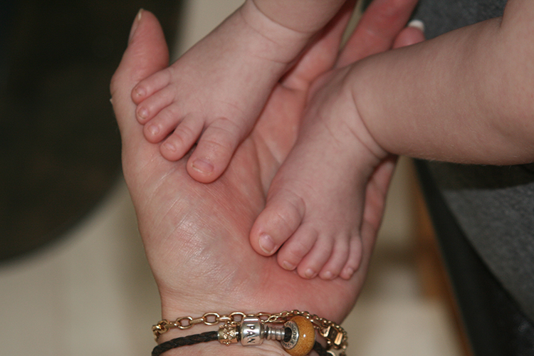 Bäbsifötter mot en handflata